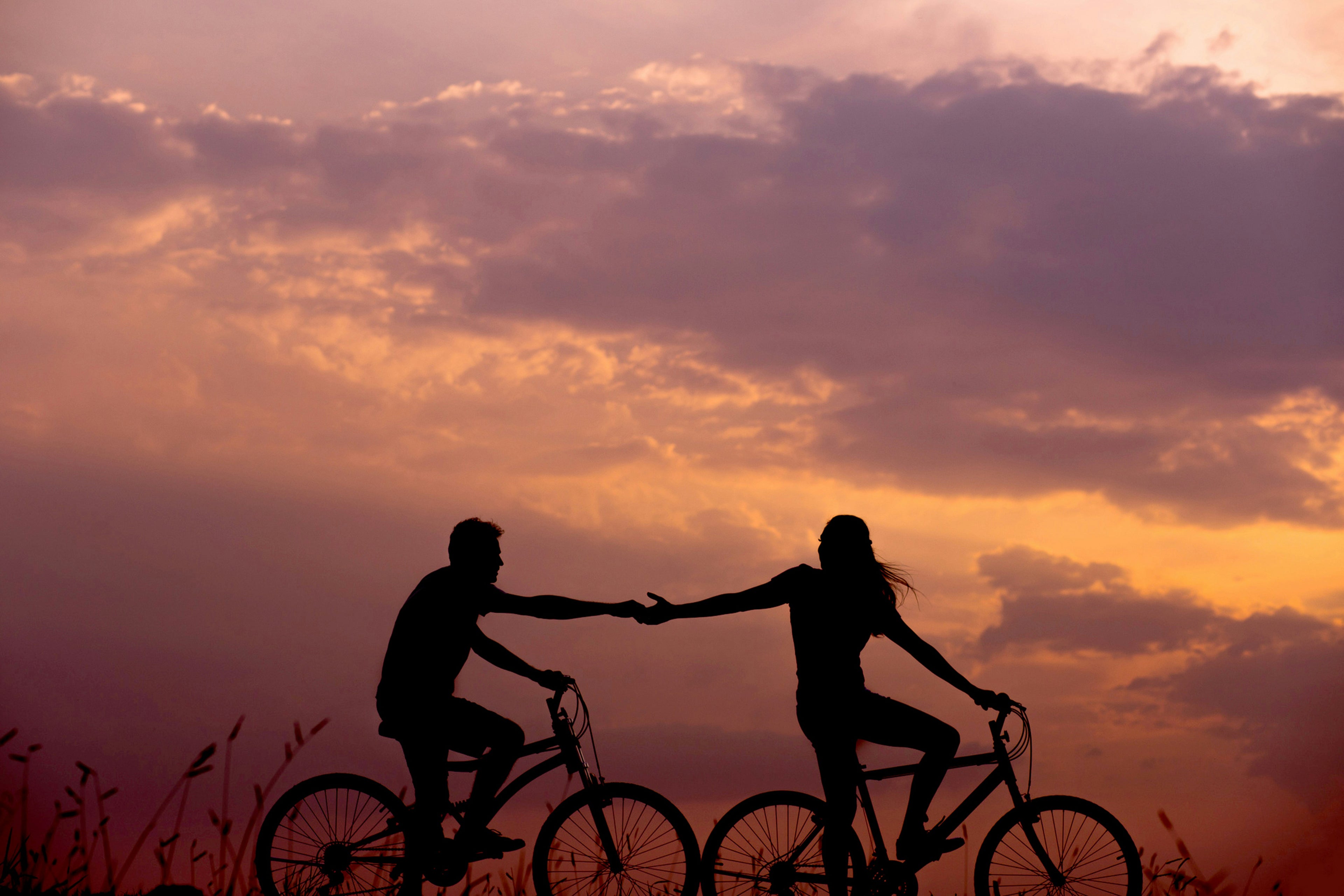 sunset with bikers holding hands